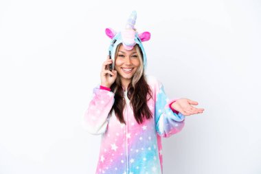 Beyaz arka planda izole edilmiş tek boynuzlu at pijaması giyen genç bir Rus kadın cep telefonuyla sohbet ediyor.