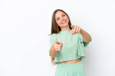 Genç Litvanyalı kadın beyaz arka planda izole edilmiş, mutlu bir ifadeyle ön tarafı işaret ediyor.