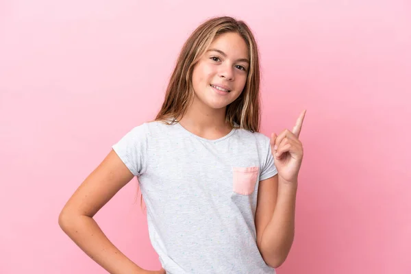 ピンクの背景に孤立した小さな白人の女の子ショーと最高の兆候で指を持ち上げる — ストック写真