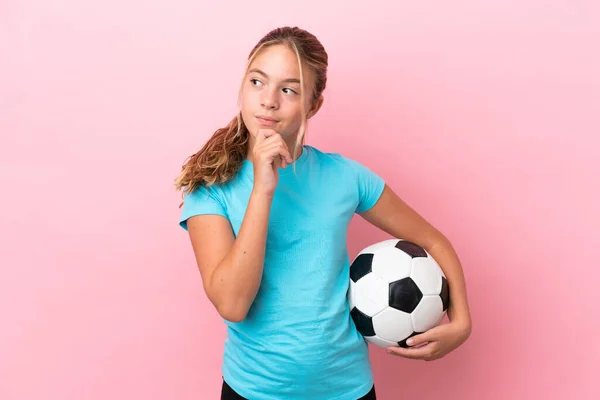 Little Piłkarz Dziewczyna Izolowane Różowym Tle Patrząc Górę — Zdjęcie stockowe