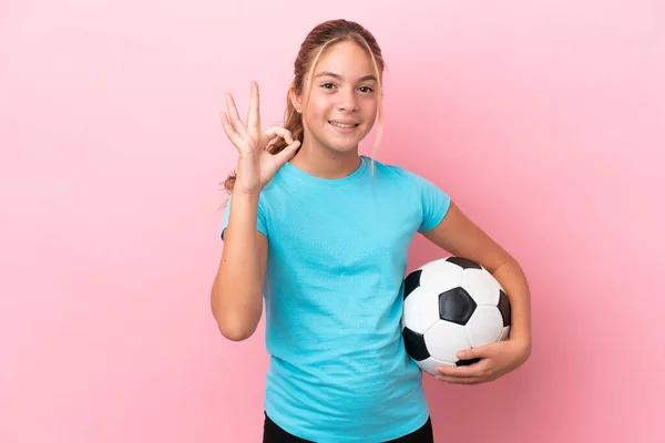 足球小女孩被隔离在粉色的背景上 手指显示出可控的标志 — 图库照片