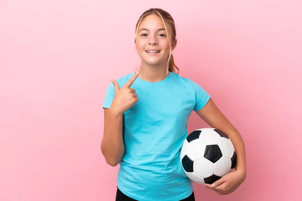 一个被粉色背景隔离的足球小女孩举起了一个大拇指 — 图库照片