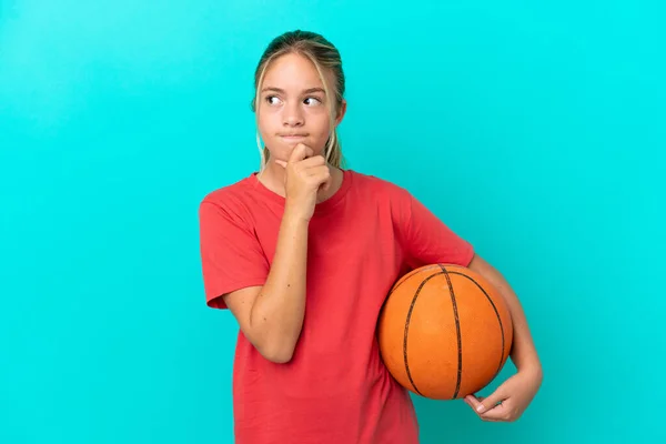 Little Caucasian Girl Playing Basketball Isolated Blue Background Having Doubts — Stock Photo, Image