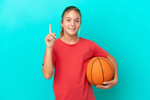 小さいですCaucasian女の子遊びバスケットボール孤立した上に青の背景を指す素晴らしいアイデア — ストック写真