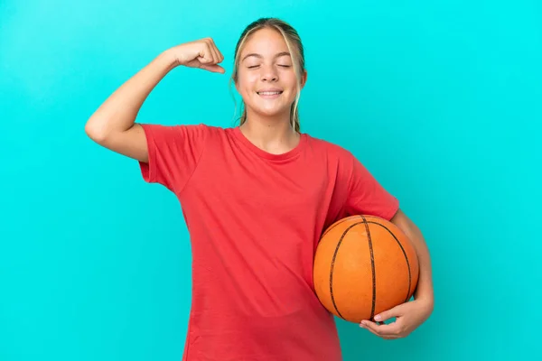 小さなCaucasian女の子プレイバスケットボール孤立した上の青の背景に強いジェスチャーを行う — ストック写真