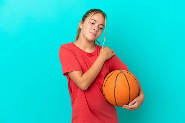 在蓝色背景下打篮球的一个高加索小女孩 由于付出了巨大的努力 肩膀感到疼痛 — 图库照片