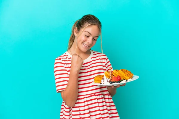 Little Caucasian Girl Holding Waffles Isolated Blue Background Celebrating Victory — 图库照片