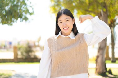 Dışarıdaki güzel Çinli kadın güçlü bir jest yapıyor.