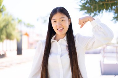 Dışarıdaki güzel Çinli kadın güçlü bir jest yapıyor.