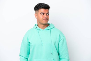 Beyaz arka planda izole edilmiş beyaz, yakışıklı genç bir adam şüpheli hareketler yapıyor.