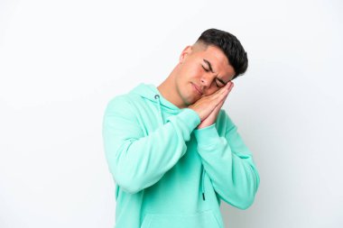 Beyaz arka planda izole edilmiş beyaz tenli yakışıklı genç adam hareketli bir uyku hareketi yapıyor.