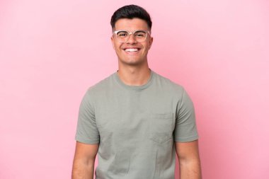 Beyaz tenli yakışıklı adam pembe arka planda izole edilmiş gülüyor.
