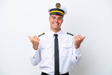 Uçak pilotu beyaz arka planda izole edilmiş beyaz bir adam. Baş parmakları havada ve gülümsüyor.