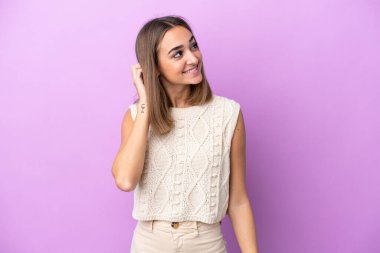 Mor arka planda izole edilmiş genç beyaz kadın bir fikir düşünüyor.