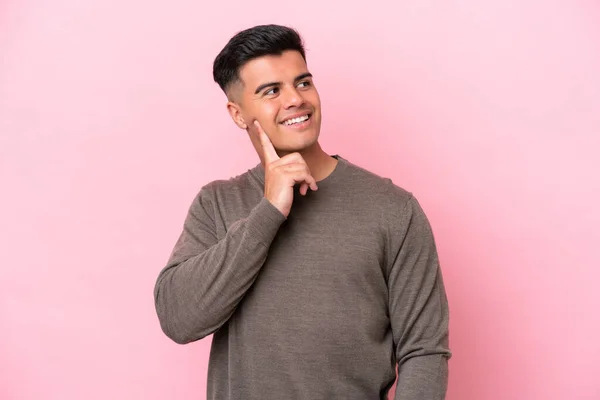 stock image Young caucasian handsome man isolated on pink background thinking an idea while looking up