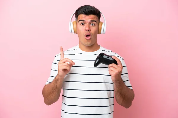 Νεαρός Όμορφος Άνδρας Που Παίζει Ένα Χειριστήριο Βιντεοπαιχνιδιών Απομονωμένος Ροζ — Φωτογραφία Αρχείου