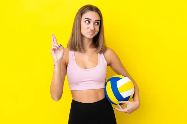 Молода Жінка Грає Волейбол Ізольовано Жовтому Тлі Пальцями Перетинаються Бажають — стокове фото