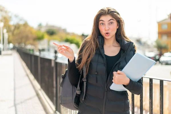 Junge Studentin Mit Isoliertem Hintergrund Überrascht Und Zeigt Seite — Stockfoto