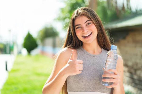 Jonge Blanke Vrouw Met Een Fles Water Buiten Met Duimen — Stockfoto