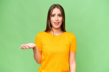 Young pretty caucasian woman over isolated background making doubts gesture