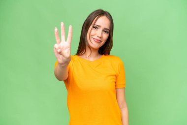 Genç, güzel, beyaz bir kadın izole edilmiş geçmişinden mutlu ve parmaklarıyla üçe kadar sayıyor.