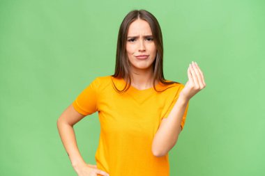 Genç, beyaz bir kadın, izole edilmiş arka planda İtalyan jestleri yapıyor.