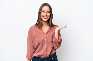 Beyaz arka planda izole edilmiş beyaz tenli genç bir kadın bir ilan vermek için avucunda hayali bir fotokopi makinesi tutuyor.