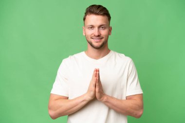 Tecrit edilmiş geçmişi olan genç sarışın, beyaz bir adam avuç içlerini bir arada tutuyor. İnsan bir şey ister.