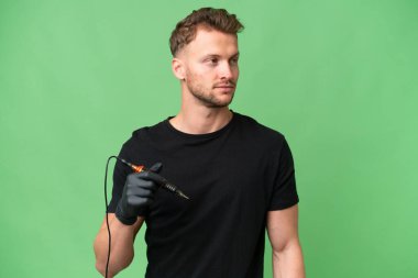 Dövme sanatçısı Kafkas arka planda yalıtılmış bir adam yan tarafa bakıyor