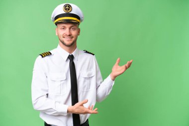Uçak pilotu izole edilmiş arka planda. Davet edilmek için ellerini yana uzatıyor.