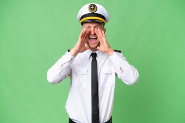 Uçak pilotu arka planda bağırıyor ve bir şey duyuruyor.