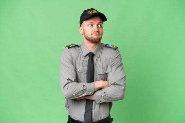 İzole edilmiş arka planda genç bir beyaz adam omuzlarını kaldırırken şüpheyle hareket ediyor.