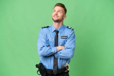 İzole edilmiş bir geçmişi olan genç bir polis gülümserken yukarı bakıyor.