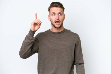 Beyaz arka planda izole edilmiş genç sarışın beyaz adam çözümü bulmak için parmağını kaldırıyor.