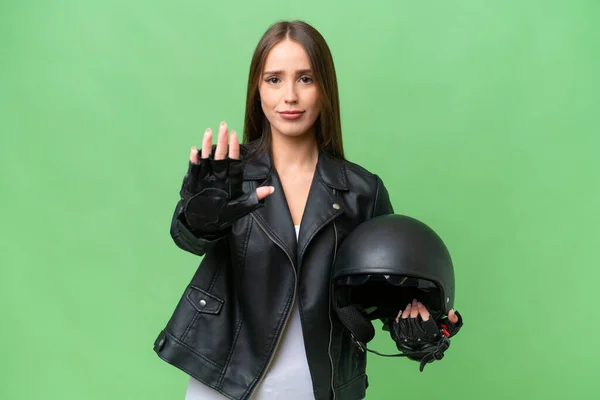 stock image Young pretty caucasian woman with a motorcycle helmet over isolated background making stop gesture