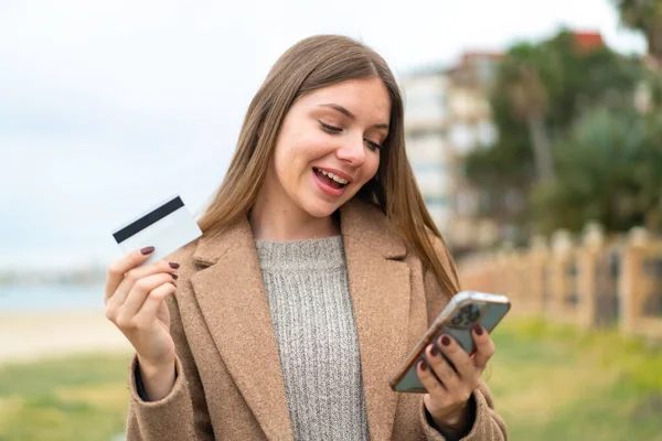 Jonge Mooie Blonde Vrouw Kopen Met Mobiele Telefoon Met Een — Stockfoto