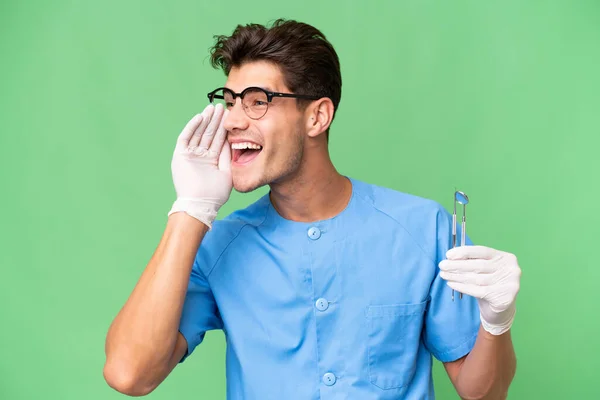 Jovem Dentista Homem Segurando Ferramentas Sobre Fundo Isolado Gritando Com — Fotografia de Stock