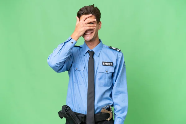 Jovem Policial Sobre Fundo Isolado Cobrindo Olhos Por Mãos Sorrindo — Fotografia de Stock