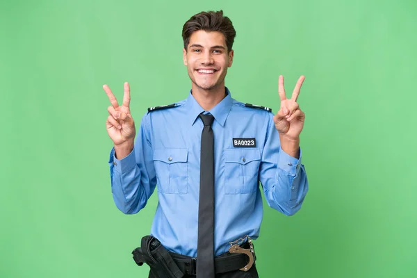 Młody Policjant Odosobnionym Tle Pokazuje Znak Zwycięstwa Obiema Rękami — Zdjęcie stockowe