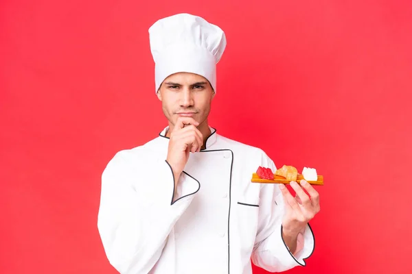 Junger Kaukasischer Koch Hält Sashimi Isoliert Auf Rotem Hintergrund — Stockfoto