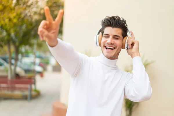 Молодий Кавказький Чоловік Вулиці Слухає Музику Співає — стокове фото