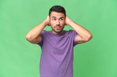 Tecrit edilmiş, sinirli ve kulakları kapalı genç beyaz bir adam.