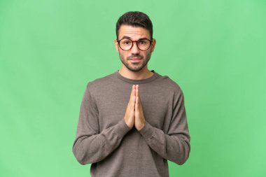 Tecrit edilmiş geçmişi olan yakışıklı beyaz bir adam avuç içlerini bir arada tutuyor. İnsan bir şey ister.