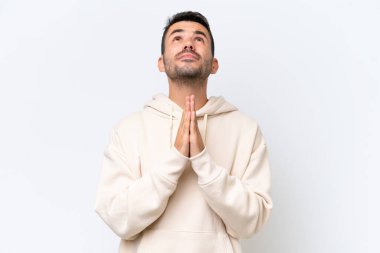 Beyaz arka planda izole genç beyaz adam avuç içlerini bir arada tutuyor. İnsan bir şey ister.