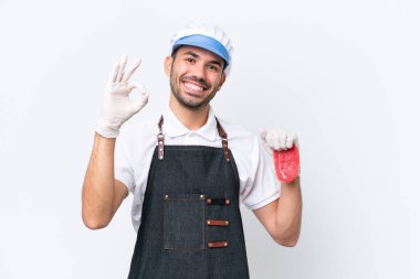 Kasap beyaz önlük giymiş ve izole edilmiş beyaz arka planda taze et servis ediyor.