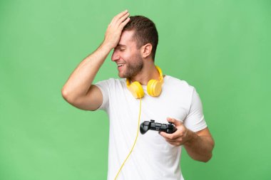 Yeşil krom arka planda izole edilmiş bir video oyunu kontrolörüyle oynayan genç yakışıklı bir adam bir şey fark etti ve çözümü amaçladı.