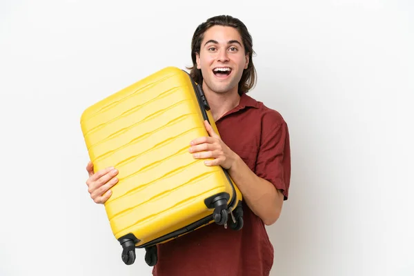 若いですハンサムな男隔離された上の白い背景で休暇で旅行スーツケースと驚き — ストック写真