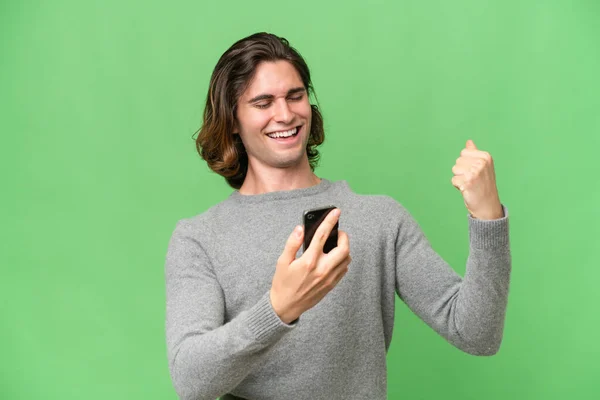 Young Caucasian Man Isolated Green Chroma Background Phone Victory Position — Stock Photo, Image