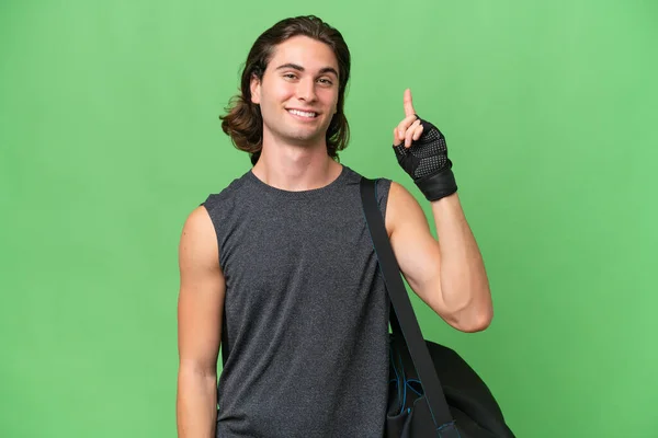 年轻英俊的体育男子孤立在绿色的色彩背景下 显示并举起一个手指表示最好的迹象 — 图库照片