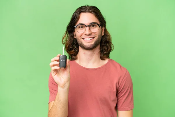 Mladý Pohledný Muž Drží Klíče Auta Přes Izolované Pozadí Úsměvem — Stock fotografie